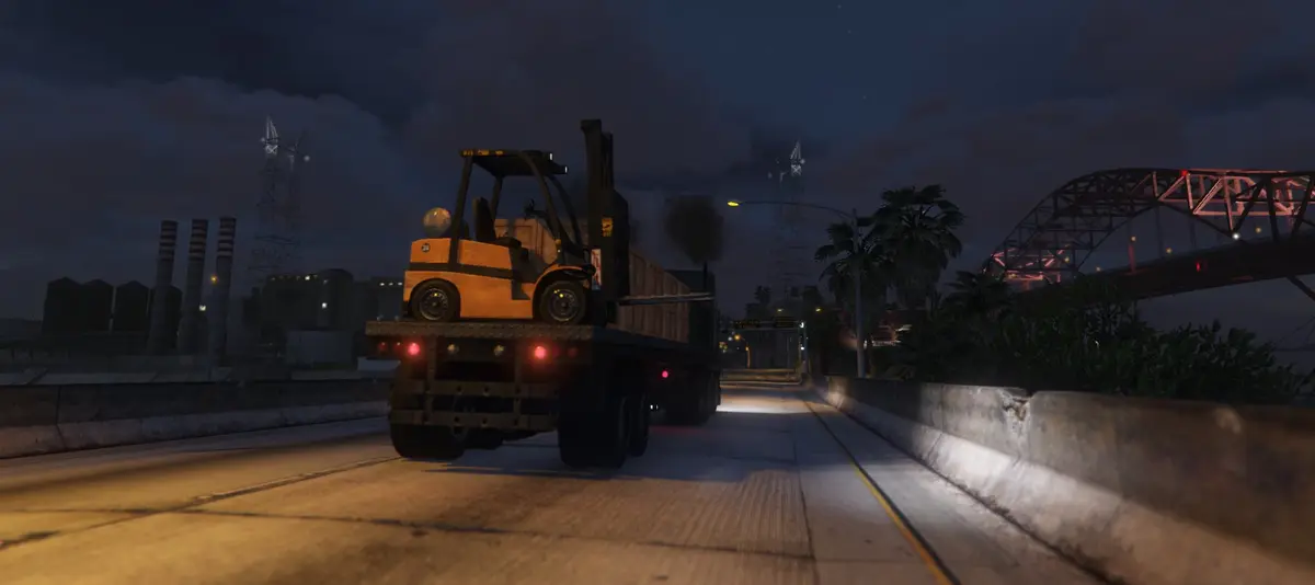 A forklift loading a truck at night